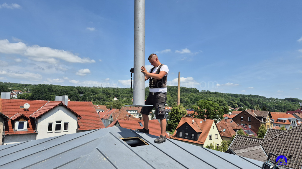 Dachdecker Karl Spangenberg installiert einen 1&1 Funkmast auf einen Stehfalzdach in Eisenach