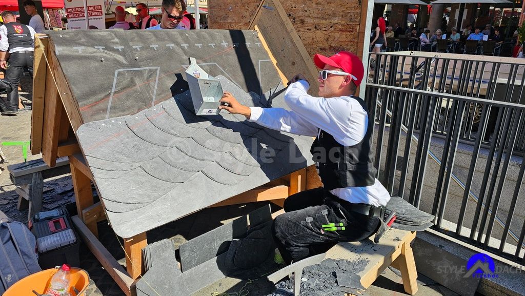 Schieferdecker Azubi Justin Härtel, alias Schiefer Henry nagelt ein Schiefer Modell auf dem Leipziger Marktplatz zum Azubi Cup 2025