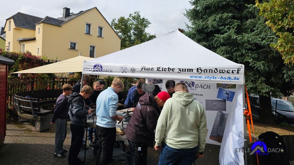 Die Schul-Skills an der Sophienschule Colditz 2025. Das Foto zeigt einen Stand der Dachdecker Style Dach auf dem Schulhof der Sophienschule Colditz. Vor dem Stand stehen Schüler der Klassen 7, 8, 9 und 10