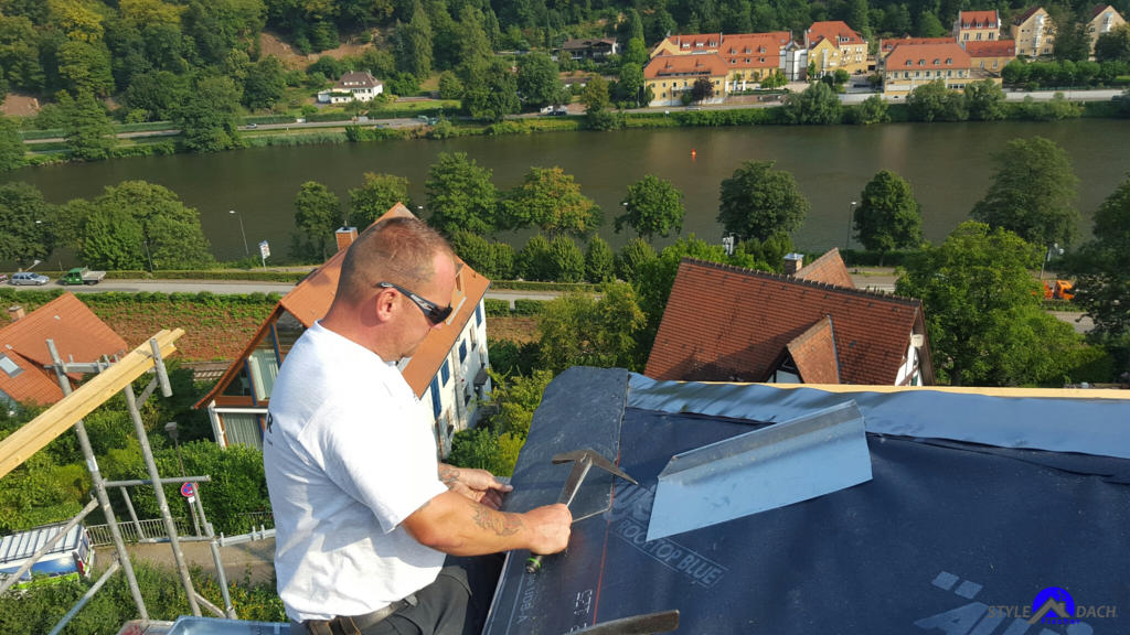 Dachdecker beim Nageln von Rathscheck Uni Schiefer in Heidelberg auf einem Schieferdach. Schieferdecker Mirko Fischer